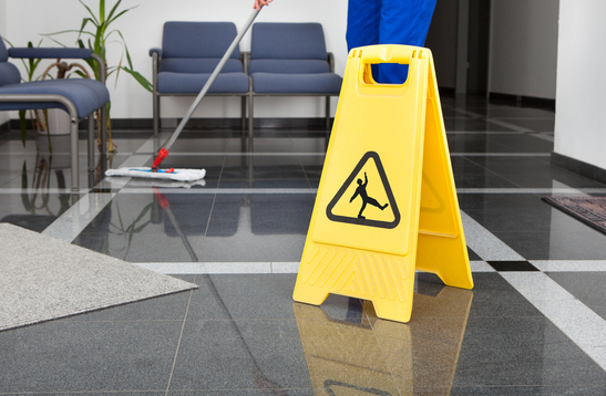 commercial-cleaning-services-man-with-mop-and-wet-floor-sign